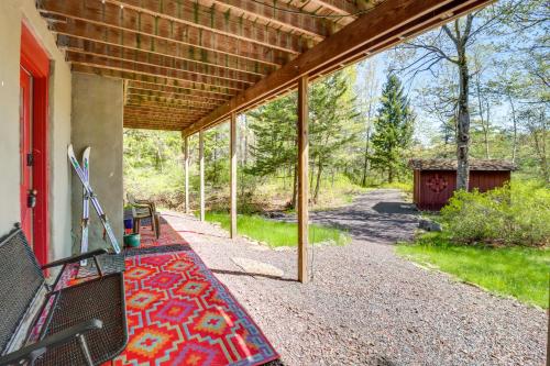 a porch of a house with a rug on it at Swim Dock and Game Room Lakefront Poconos Cabin! in Long Pond