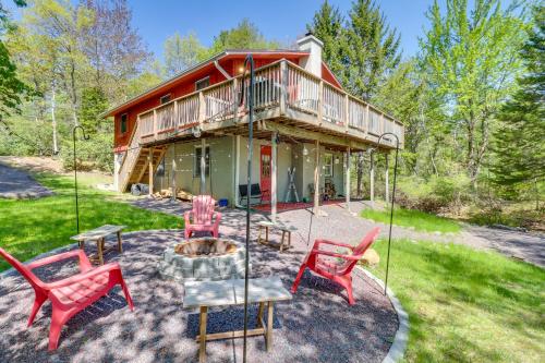 a house with red chairs and a fire pit at Swim Dock and Game Room Lakefront Poconos Cabin! in Long Pond