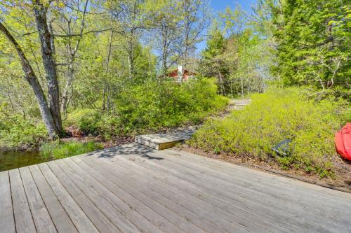 a wooden boardwalk leading to a path in the woods at Swim Dock and Game Room Lakefront Poconos Cabin! in Long Pond