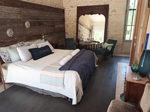 a bedroom with a large bed and a table at Le Clos Réaud in Blaye