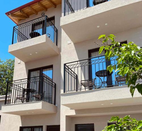 a building with balconies with tables and chairs on it at Oro in Skiathos