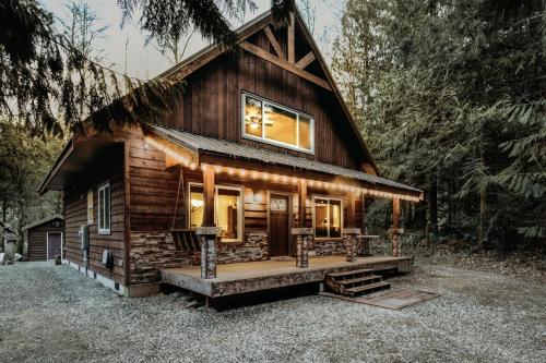 a log cabin in the woods with a large window at 22MBR - Wi-Fi - Fireplace - Pets OK - Sleeps 8 cabin in Glacier