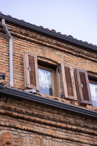a window with shutters on a brick building at Bujtina Sidheri in Korçë