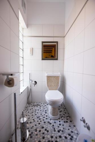 a bathroom with a toilet and a tiled floor at Bujtina Sidheri in Korçë