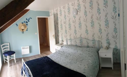 a bedroom with a bed and a blue wall at Charming traditional 2-Bed Cottage near Plemet in Plémet