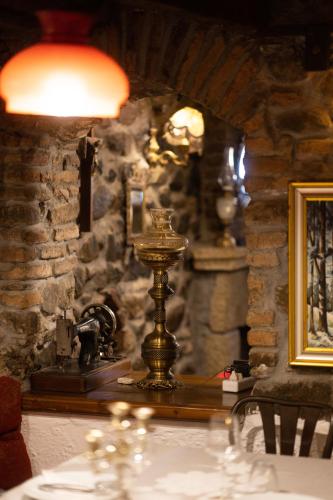 a table with a phone in a room with a stone wall at Bujtina Sidheri in Korçë
