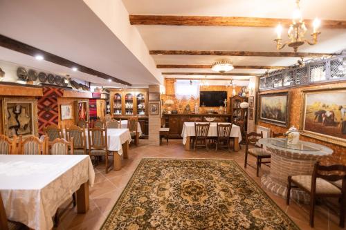 a restaurant with tables and chairs and a tv at Bujtina Sidheri in Korçë