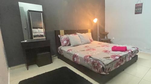 Chempaka Kluang Homestay في كلوانج: غرفة نوم صغيرة مع سرير ومرآة