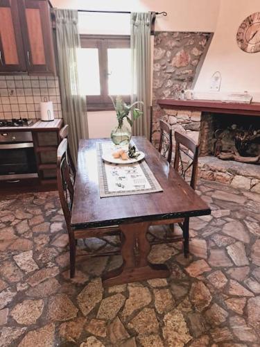 a wooden table in a kitchen with a fireplace at Fragosiko - Rustic Retreat in Kefalonia in Argostoli