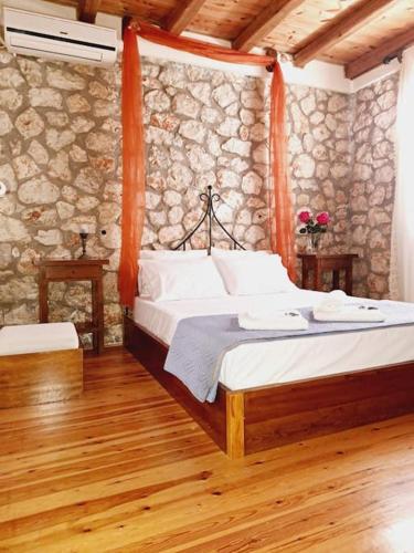 a bedroom with a bed and a stone wall at Fragosiko - Rustic Retreat in Kefalonia in Argostoli