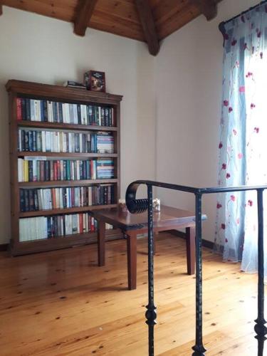 a room with a table and a book shelf with books at Fragosiko - Rustic Retreat in Kefalonia in Argostoli