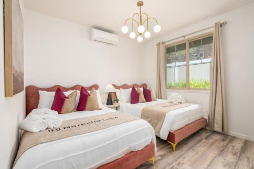 a bedroom with two beds and a window at #ML - Aloha Hoʻonani 3BR Home - MT & Ocean Views! in Waianae