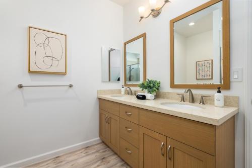 a bathroom with a sink and a mirror at @ Marbella Lane - 3BR w/ Phenomenal Ocean+MT views in Waianae