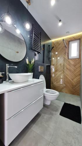 a bathroom with a white sink and a toilet at Domki Wenta in Łeba