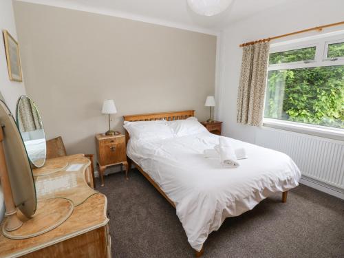 une chambre avec un lit blanc et une fenêtre dans l'établissement Ashdown House, à Saundersfoot