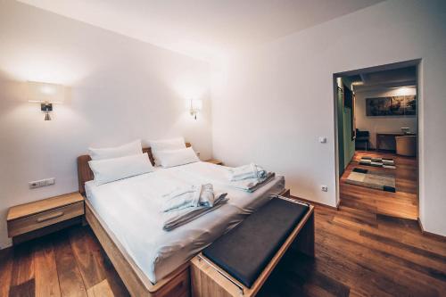 a bedroom with a large bed with white sheets at Aktivhotel Wildschütz in Gmunden