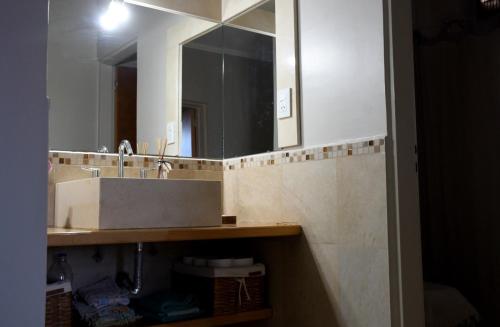 W łazience znajduje się umywalka i lustro. w obiekcie Camino a la Patagonia w mieście Santa Rosa
