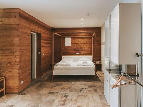 a bedroom with a bed in a room with wooden walls at Aktivhotel Wildschütz in Gmunden