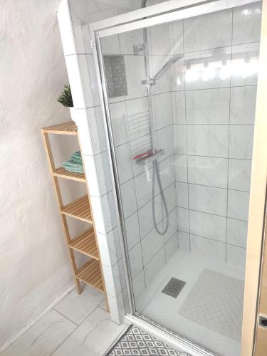 une douche avec une porte vitrée dans une salle de bain dans l'établissement Les insolites de Champeix, à Champeix