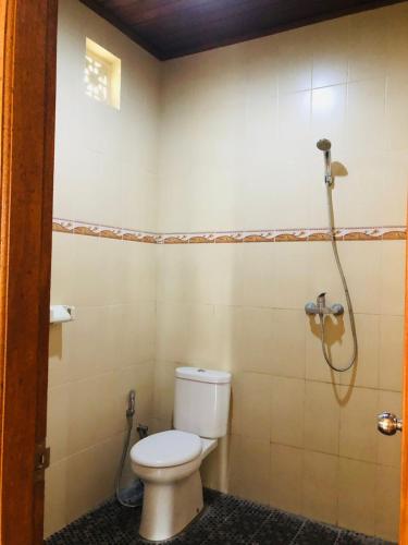 ein Bad mit einem WC und einer Dusche in der Unterkunft Parta Homestay in Ubud