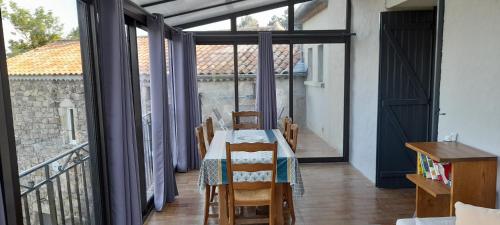 une salle à manger avec une table et un balcon dans l'établissement La Grangette du Mas, à Chassiers