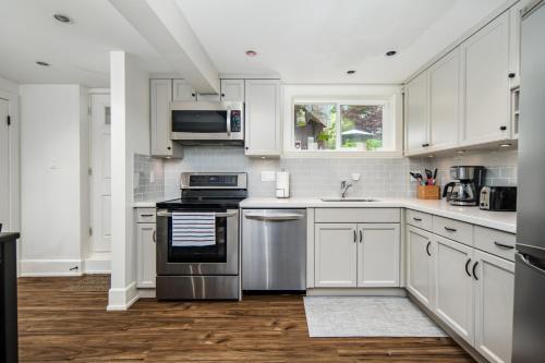 a kitchen with white cabinets and stainless steel appliances at Gorgeous 4 Bedroom Garden Level Suite at Vancouver West & UBC in Vancouver