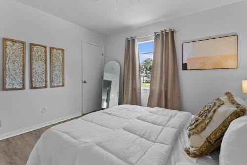 een witte slaapkamer met een groot bed en een raam bij Boho Inspired Apt in the heart of Tampa Bay! in Tampa