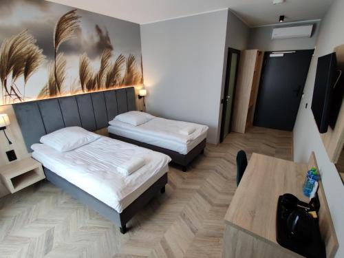 a hotel room with two beds and a table at Nowe M4 Żyrardów Centrum - blisko Suntago in Żyrardów