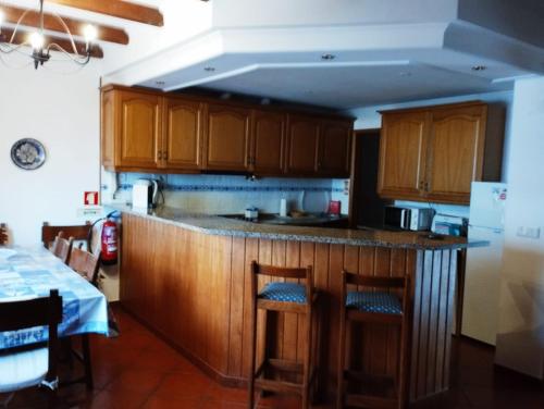 eine Küche mit Holzschränken und einer Arbeitsplatte in der Unterkunft Costa do Moinho in Longueira