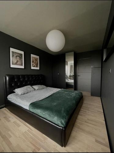 Un dormitorio con una cama grande con una manta verde. en SEASIDE APARTMENT, en Liepāja