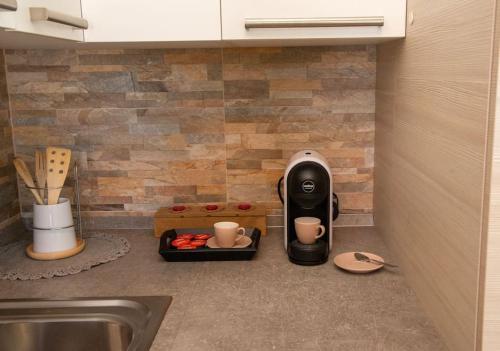 a kitchen counter with a coffee maker and a sink at *[Stella Alpina]*accogliente casa, giardini, wi-fi in Borgo Lares