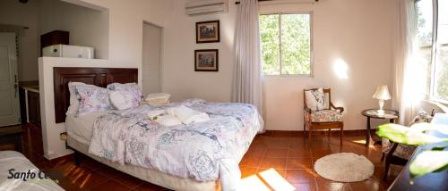 a bedroom with a bed and a chair and a window at Hotel Santo Cerro Natural Park in Santo Cerro