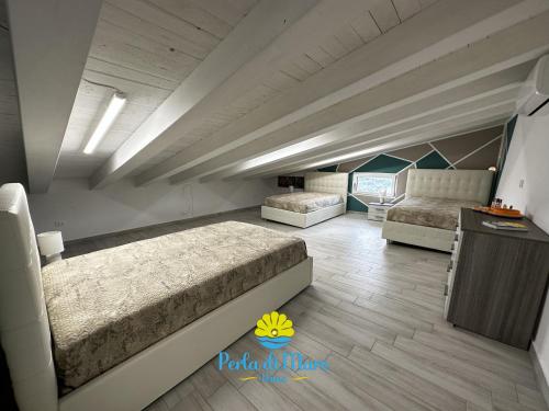 Großes Zimmer mit 2 Betten und einem Tisch in der Unterkunft Perla di Mare in Siculiana