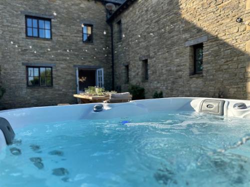 a jacuzzi tub in front of a building at Cotswolds Retreat - Bath & Castle Combe - Hot Tub in Chippenham