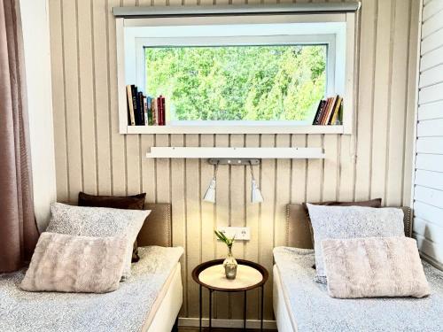 2 camas en una habitación con ventana en Lilla huset Bed & Breakfast - gästhus 1-3 personer och egen parkering en Örebro