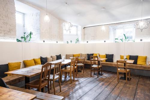 a restaurant with wooden tables and yellow cushions at Sophie's Hostel in Prague