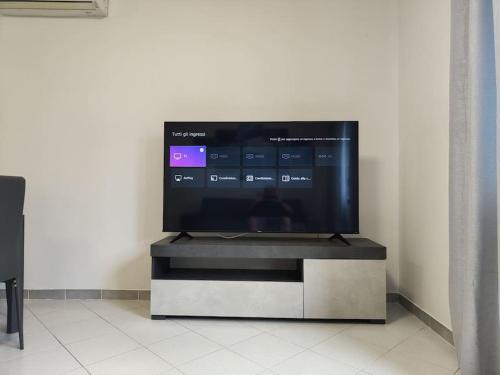 TV de pantalla plana sentada en un stand en una habitación en Casa Trezza 3, en Latina