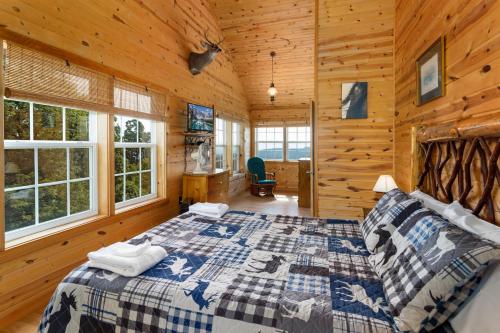 una camera con un letto in una baita di tronchi di Lookout Place a Boone