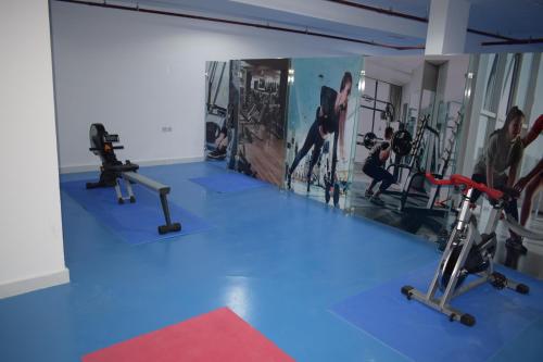 a gym with three exercise bikes on a blue floor at Atlantis International Hotel Apartments in Kuwait