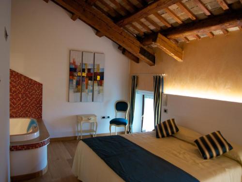 a bedroom with a bed and a bathroom with a tub at Villa Butussi - L'ospitalità del Vino in Corno di Rosazzo