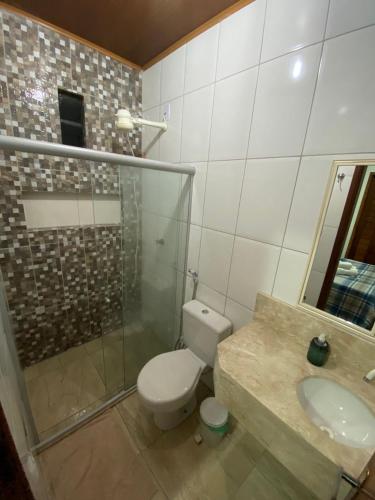e bagno con servizi igienici, doccia e lavandino. di Kitnet aconchegante próximo à Praia do Forte a Mata de Sao Joao