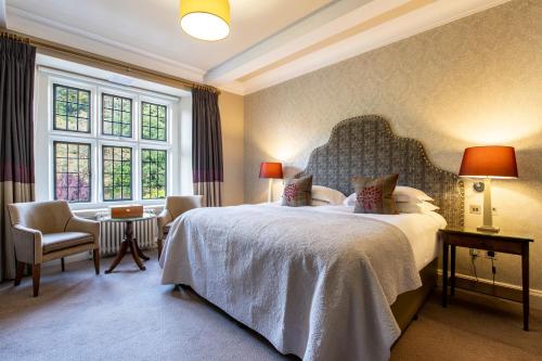 a bedroom with a large bed and a large window at Bovey Castle in Moretonhampstead