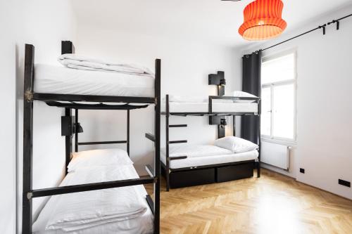 a room with three bunk beds and a window at Sophie's Hostel in Prague