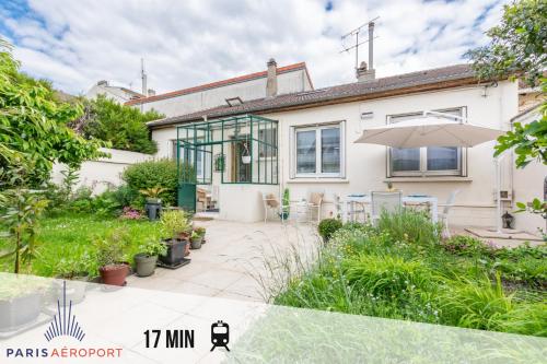 a house with a patio and an umbrella at La Maisonnette-Wifi Fibre-Netflix-Jardin-BBQ in Le Blanc-Mesnil
