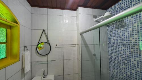 a bathroom with a shower and a sink and a mirror at Pousada Tropical Araçatiba in Praia de Araçatiba