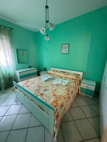 ein Schlafzimmer mit einem Bett in einem Zimmer mit grünen Wänden in der Unterkunft •Oscar Sea Home• in Seccagrande