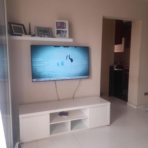 telewizor z płaskim ekranem siedzący na górze białego centrum rozrywki w obiekcie الشيخ زايد .روضه زايد w mieście Kafr Abū ʼumaydah