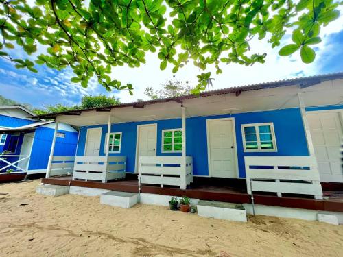 ein blaues Gebäude mit weißen Türen und Fenstern in der Unterkunft Khafii Village in Kampong Pasir Panjang