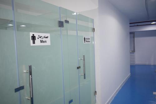 a bathroom with a glass shower with a sign on it at Atlantis International Hotel Apartments in Kuwait