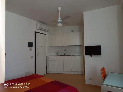 an empty room with a kitchen with a ceiling fan at Pitagora Residence in Metaponto